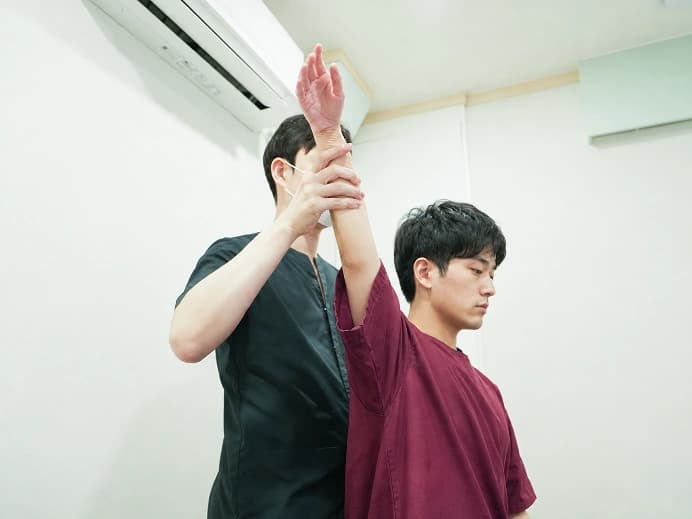 의료진이 팔의 움직임을 확인하는 검사